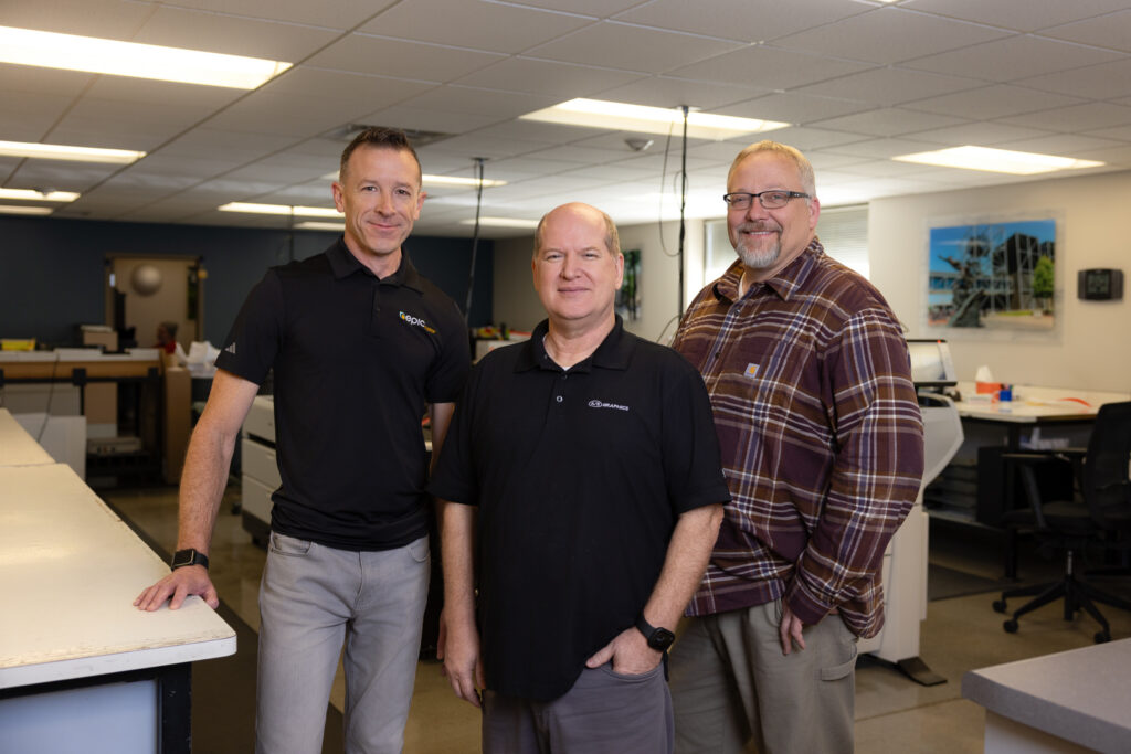Photo of Tom Taubenheim, Tim Davis and Joe Shaw standing in the A/E Graphics print production department.